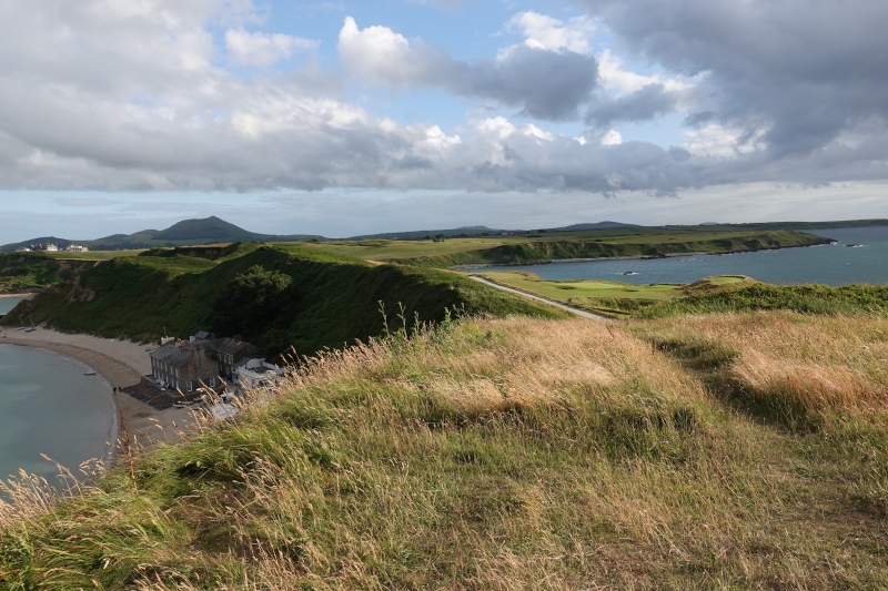 Blick auf die Landspitze zwischen Porthdinllaen and Morfa Nefyn. Man sieht sowohl rechts als auch links das Meer. In der Bucht findet man den berühmten Pub Ty Coch am Sandstrand der Bucht.